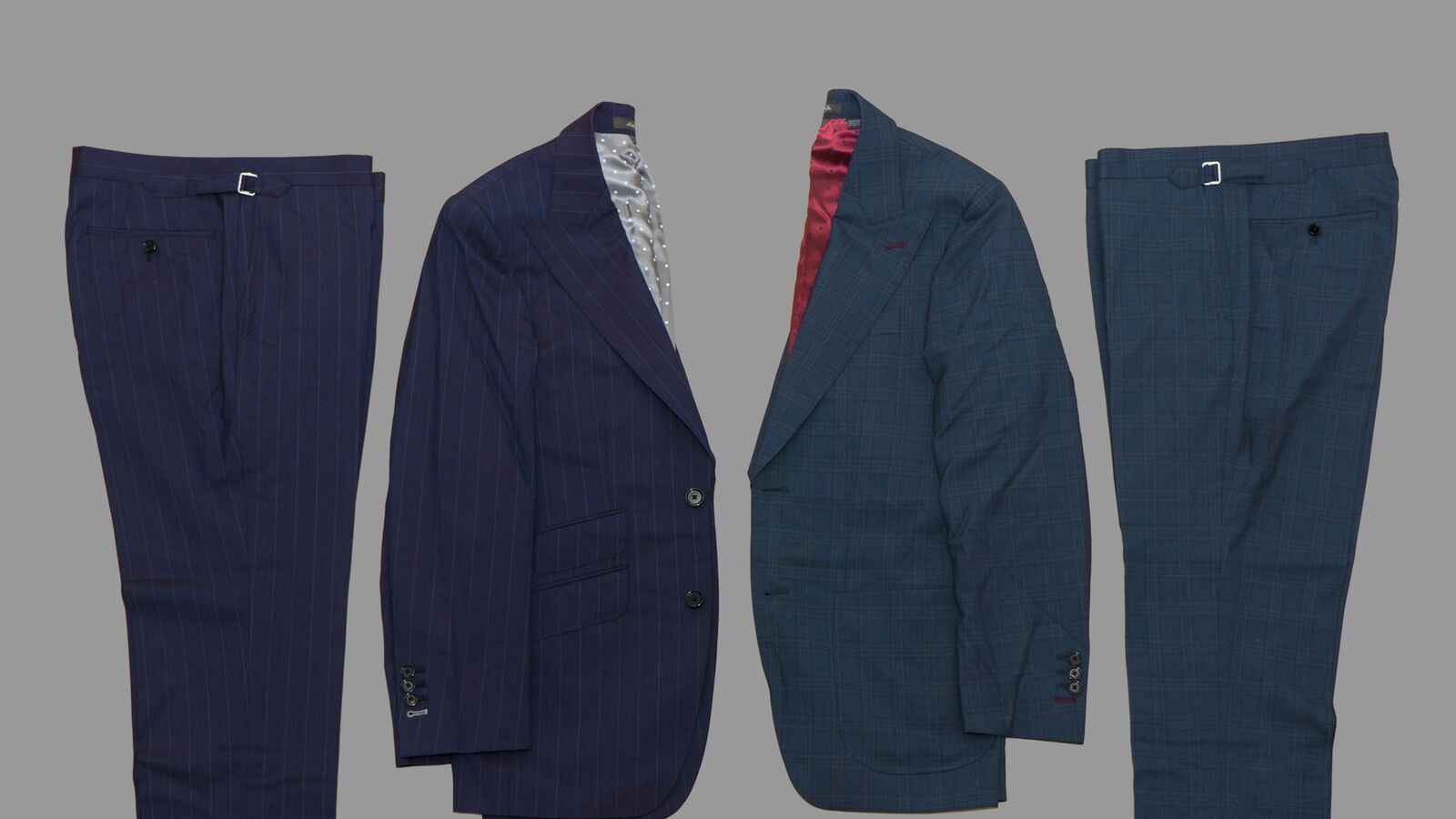 Two navy suits laid flat side by side, one pinstriped and one checked: well-fitted jackets work on camera, but fine stripes and checks can flicker